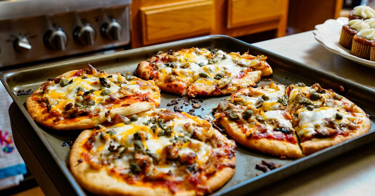 Freshly baked pizzas with melted cheese on a kitchen counter, ideal for foodies.
